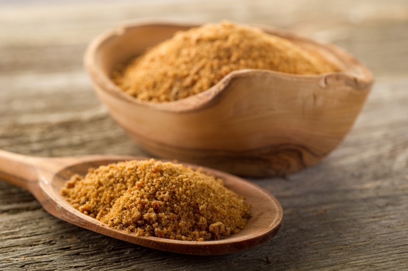 brown sugar over spoon on wood background