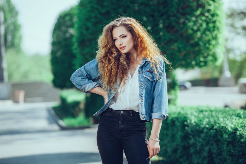 Beautiful young Caucasian girl with curly hair outdoors