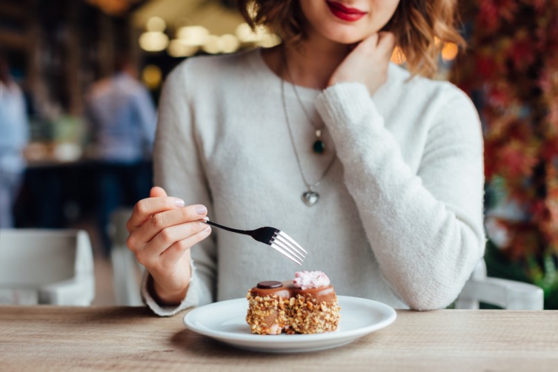 Closeup of woman eating chocolate cake in a cafe