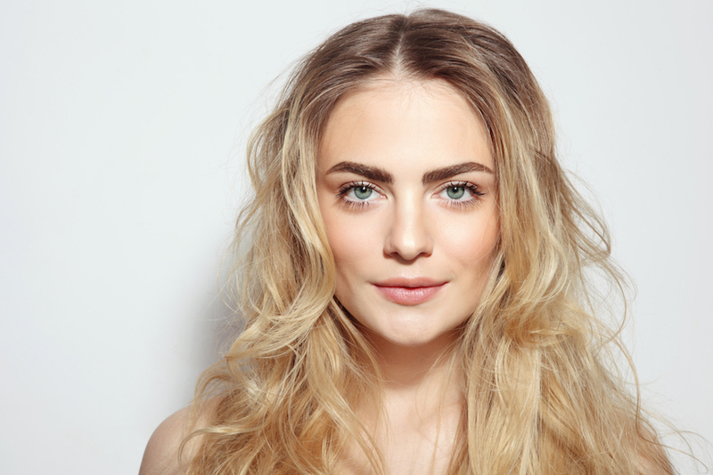 Portrait of young beautiful girl with long messy hair and clean make-up