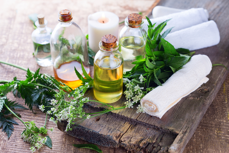 Organic essential aroma oil with herbs on aged wooden background. Homeopathy. Selective focus.