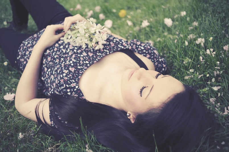 girl laying in flowers and grass