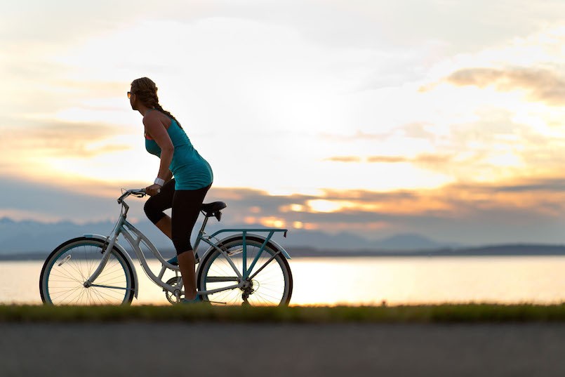 woman biking at sunset