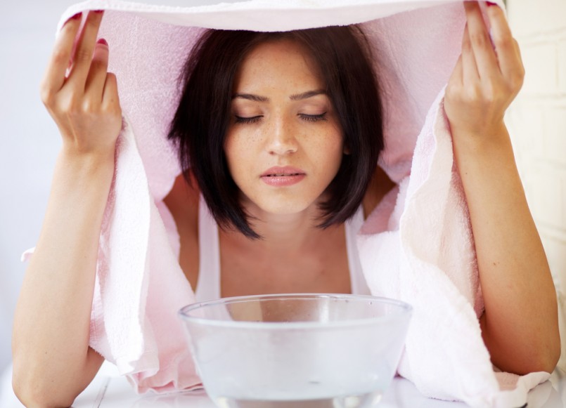 Relaxing during a facial steam treatment at a beauty spa