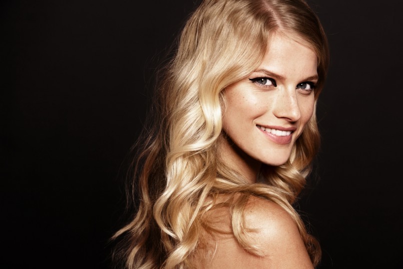 close-up portrait of smiling young woman with curly blond hair