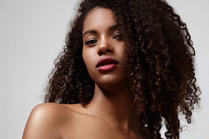 pretty black woman with a bright lipstick and curly hair