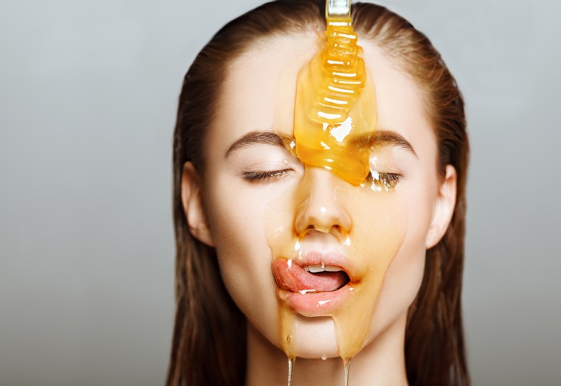 Beautiful woman with honey on her face. Healthy perfect skin. Honey treatment