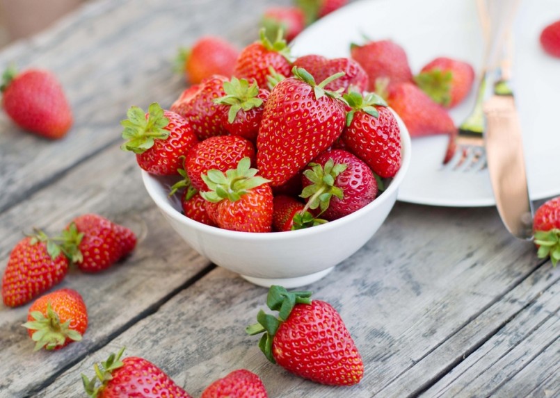Ripe red strawberries on wooden table