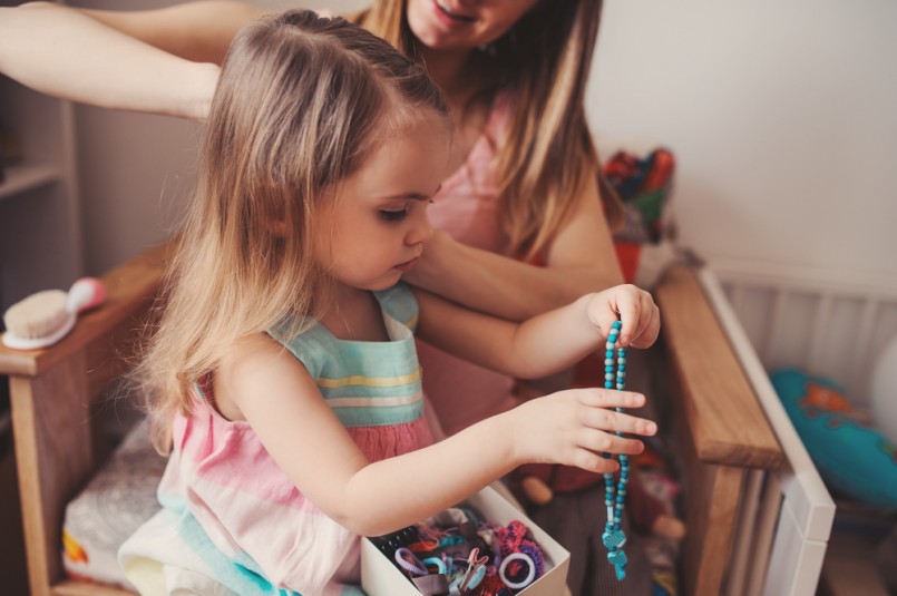 mother brushing toddler daughter's hair at home, casual lifestyle
