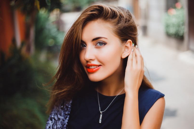 emotional portrait of Fashion stylish portrait of pretty young hipster blonde woman,going crazy,elegant black hat,soft colors,cool crazy girl.Red urban wall background.surprised girl close up