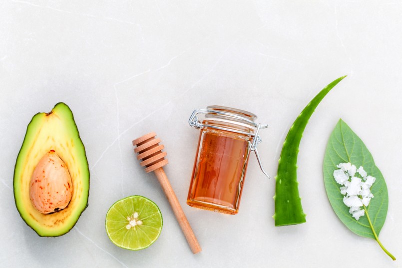 Alternative skin care and scrub fresh avocado , leaves ,sea salt , oils, lime and honey on marble background