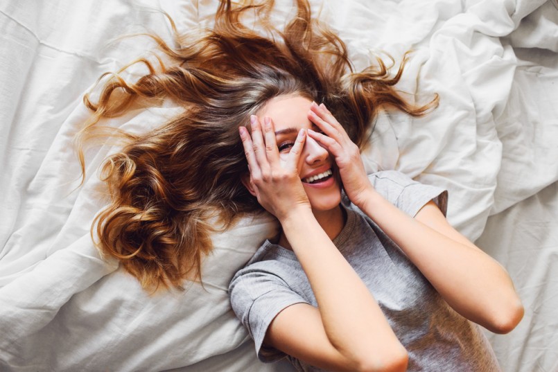 Pretty blonde woman have fine on her bedroom. Young lady enjoying her morning and wake up