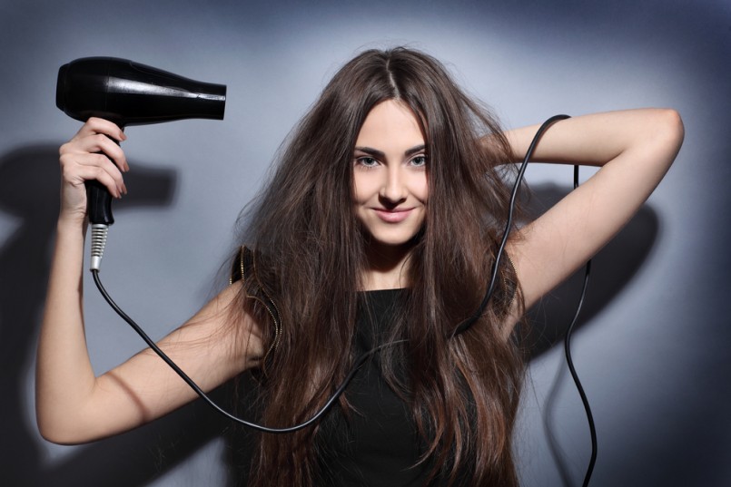 girl dries long hair hairdryer