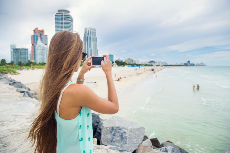 young girl model taking pictures of the ocean