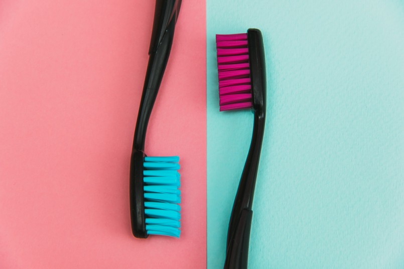 Fashion close up shot of crazy colored toothbrushes on pastel background. Minimal flat lay style