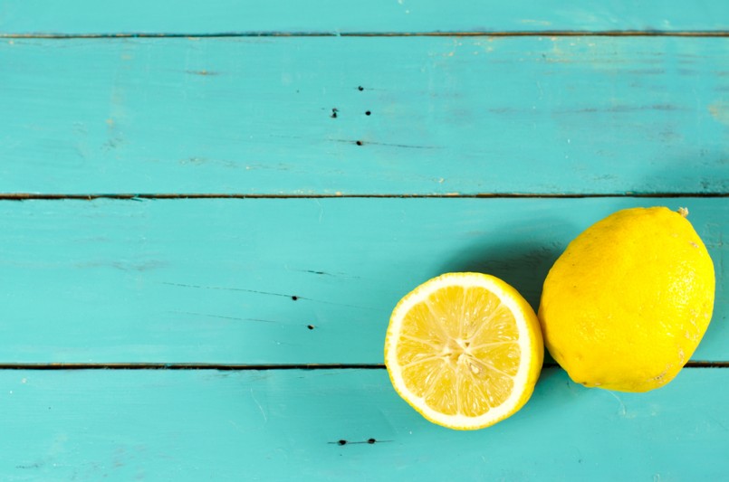 Freshly cut half and whole lemons on rustic boards