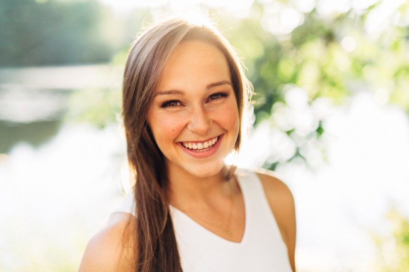 Portrait of an Attractive Young Woman Looking right at camera smiling and laughing close up
