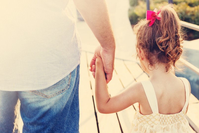 Toned portrait of Father and daughter holding hand in hand at sunset