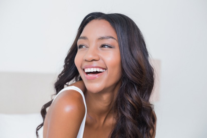 Beautiful woman smiling on bed at home in bedroom