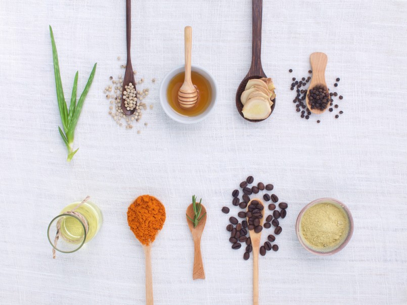 herb variety on rustic white background from top view, oil, coffee, beans, pepper, aloe vera, turmeric, ginger, rosemary