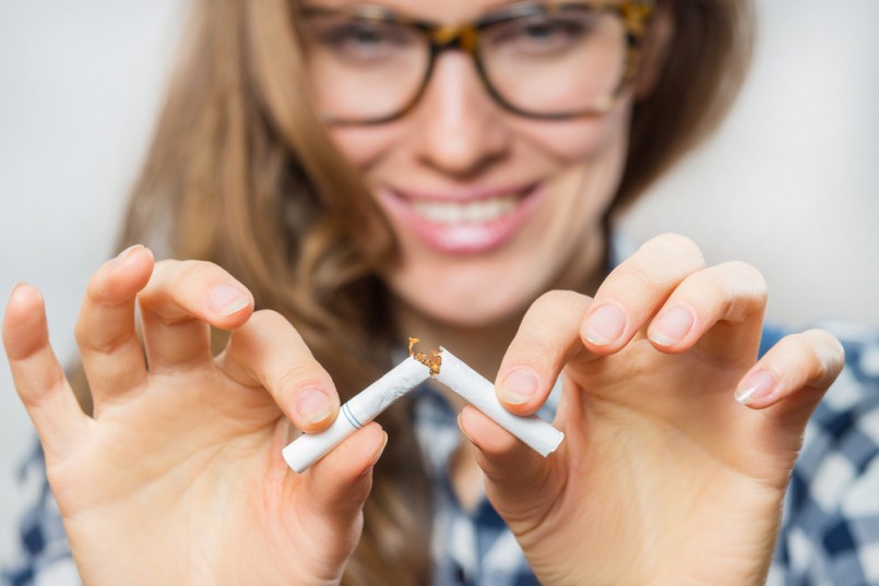 Young woman with broken cigarette. Stop smoking concept. focus on cigarette and hands