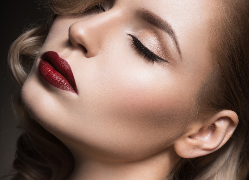 Beautiful blonde in a Hollywood manner with curls, red lips. Beauty face. Picture taken in the studio