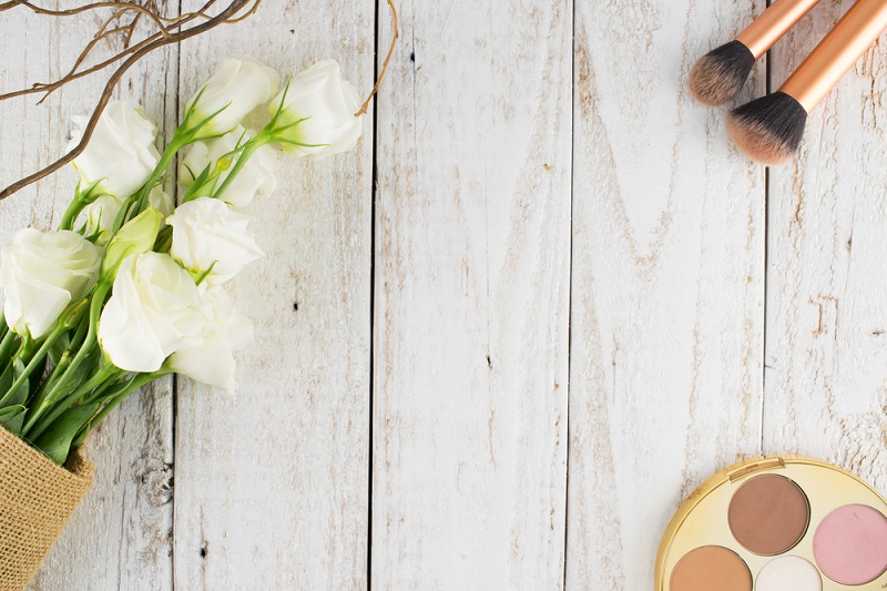 Makeup Cosmetics and White Bouquet on White Wooden Background, Flat Lay Style with Free Text Space