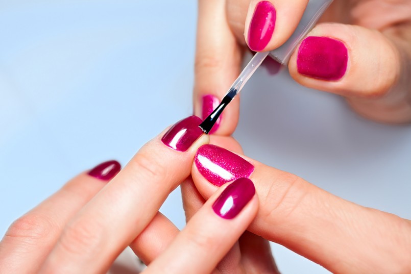 Closeup of Woman applying nail varnish to finger nails