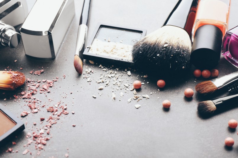 Decorative cosmetics and accessories for makeup on grey background