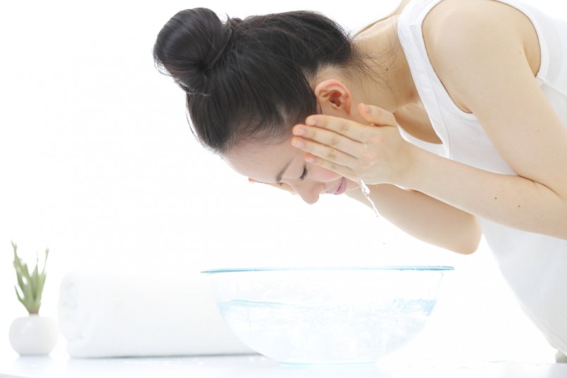 young woman washing her face in bathroom