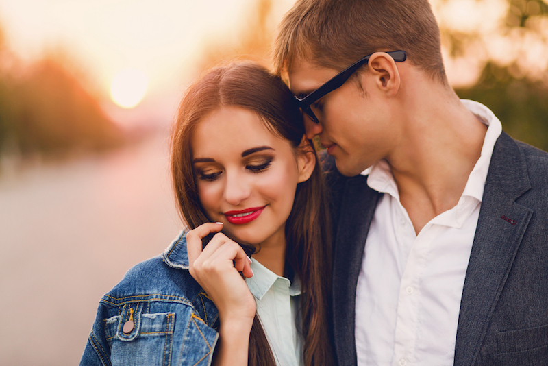 Close up lifestyle toned image of young couple in love hugging. . Pretty young girl in jeans jacket and her handsome boyfriend dating. Romantic mood.