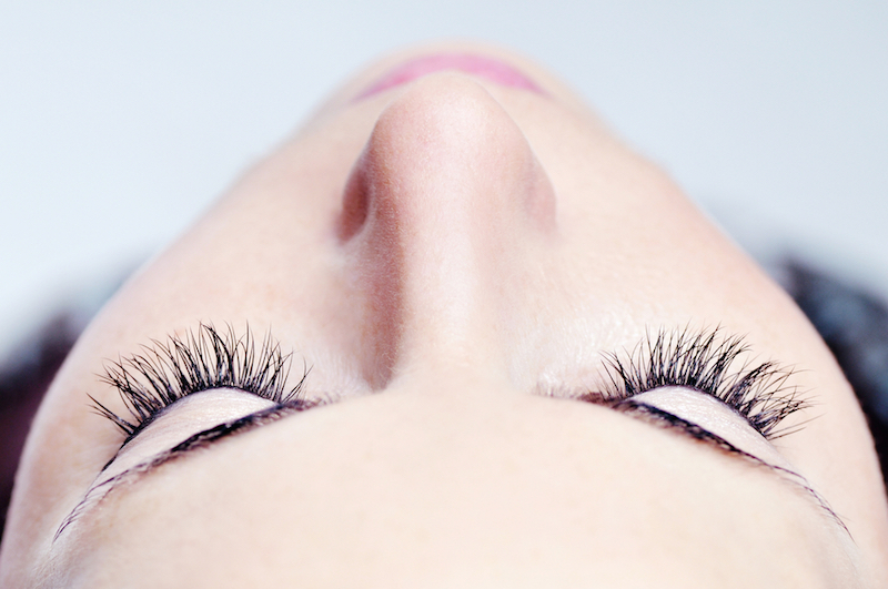 woman beautiful long eyelashes made in cosmetics salon, macro photography of pretty female eyelashes and part of face
