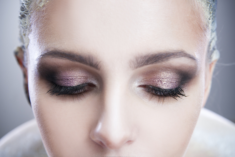 Professional beauty eyes makeup. Make up closeup. Long eyelashes and perfect skin on a gray background