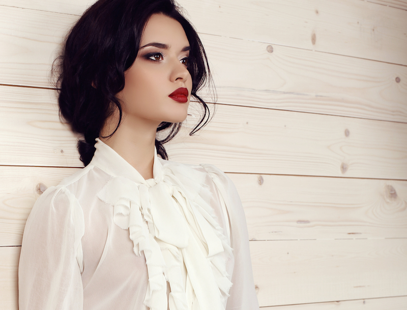 fashion studio photo of gorgeous young woman with dark hair and evening makeup,wears elegant clothes