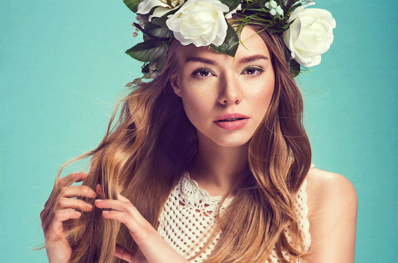 A portrait of a young beautiful woman with white flowers on the head. Spring fashion photo