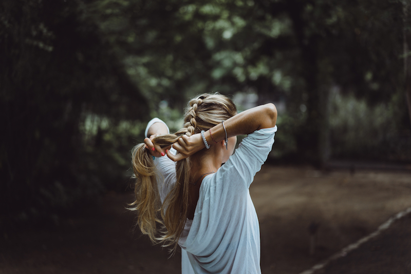 beautiful girl with long hair braids hair spike. beautiful girl braids hair before surfing